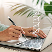 person writing on a laptop next to a plant with checklist boxes symbolizing task completion related to 12 important points