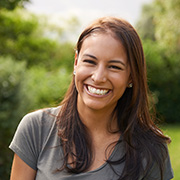smiling woman in outdoor park surrounded by greenery showcasing happiness and contentment with tips for 10 positive vibes