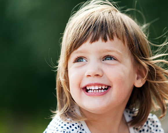 smiling child with brown hair enjoying nature five years old joyful expression