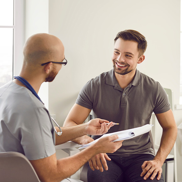 two men having a friendly consultation in a medical office discussing health and treatment options for nine important concerns